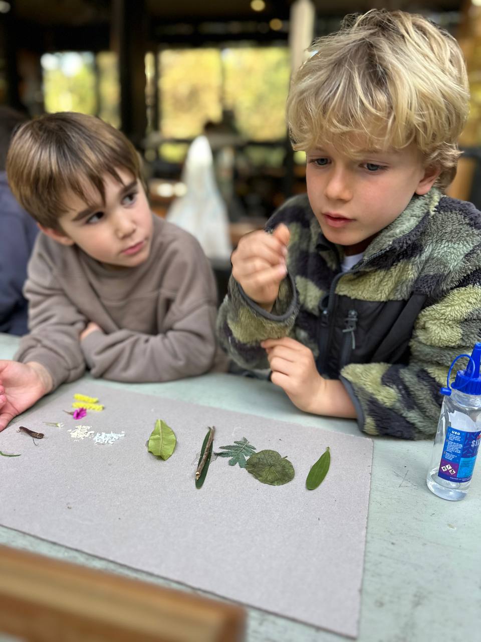 Los niños crean hormigas y hormigueros con arcilla, hojas, ramitas y otros elementos de la naturaleza para el libro colectivo.