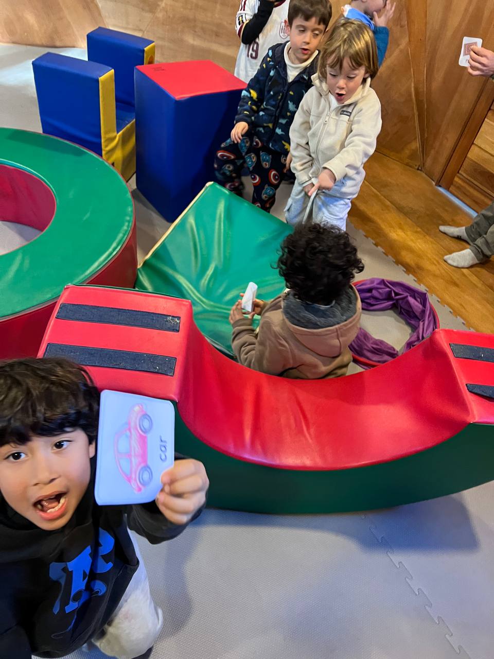 Casa de Niños B: exploración con bloques, clasificación de flashcards de vocabulario y ronda musical con guitarra.