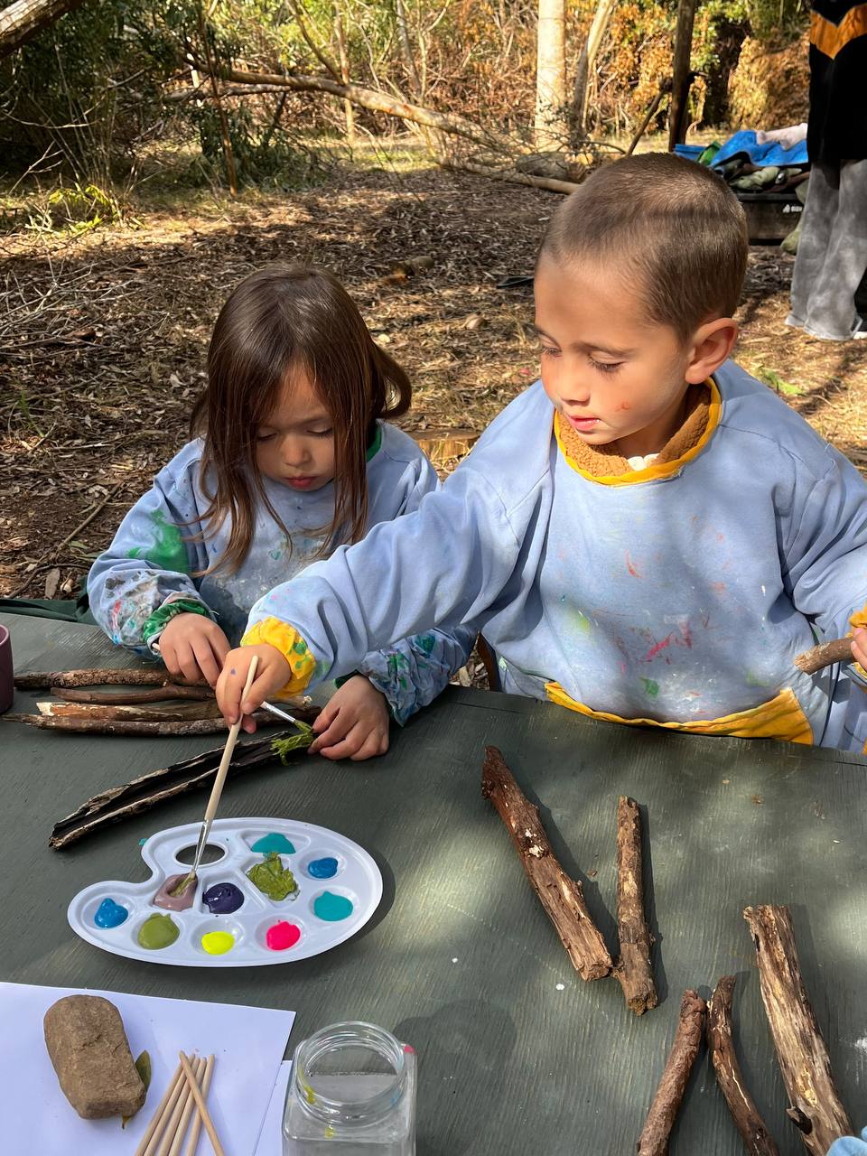 Niños pintando una rama