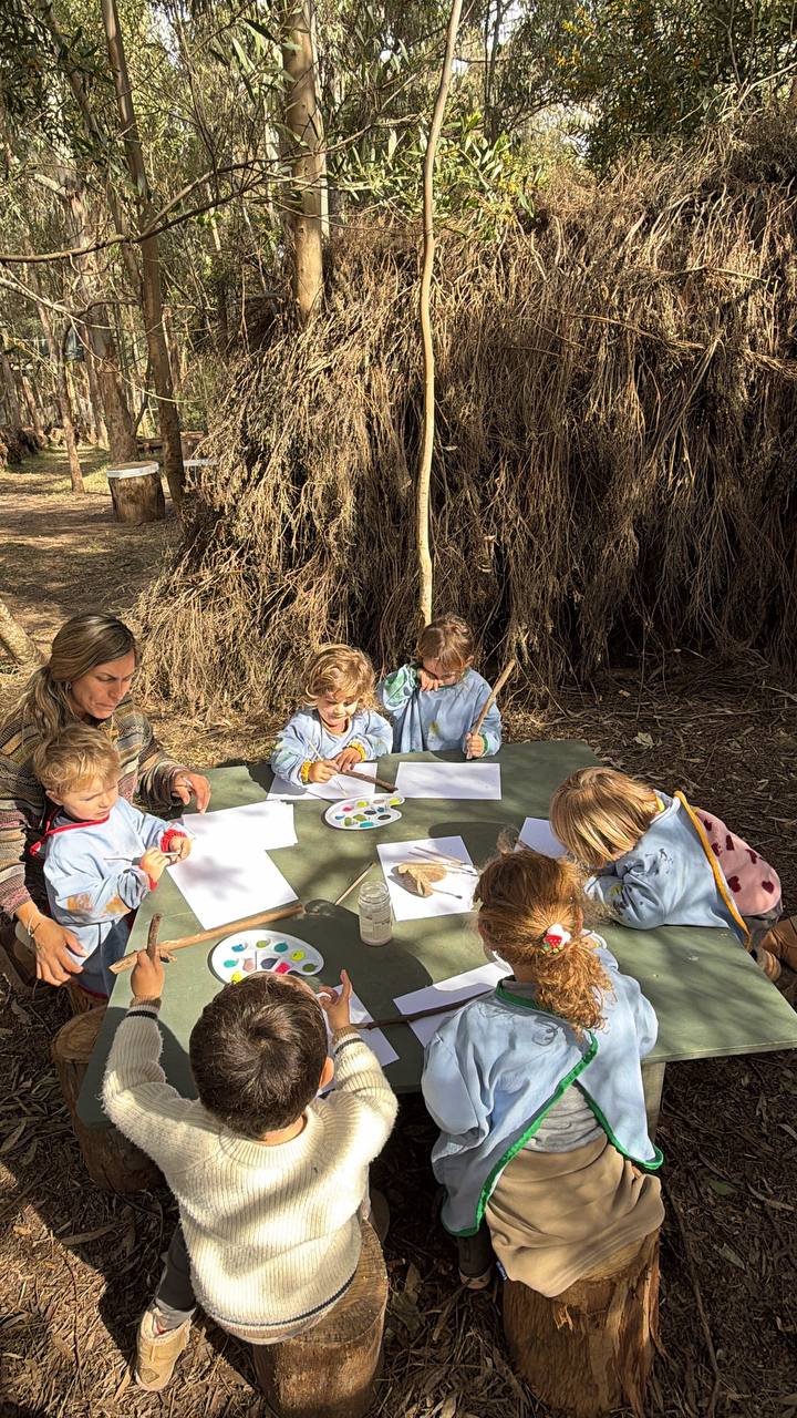 Niños compartiendo la pintura en el bosque