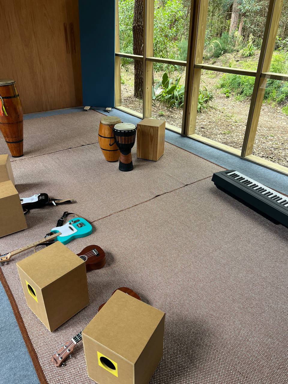 Guitarras eléctricas Loog, percusión y teclado dispuestos en el espacio de Expresión Musical.