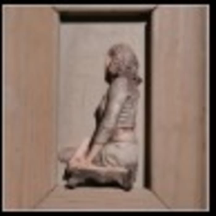 Figura sentada en caja