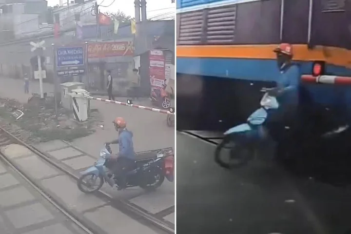 Cyclist just inches from being crushed by a train after crossing safety barrier