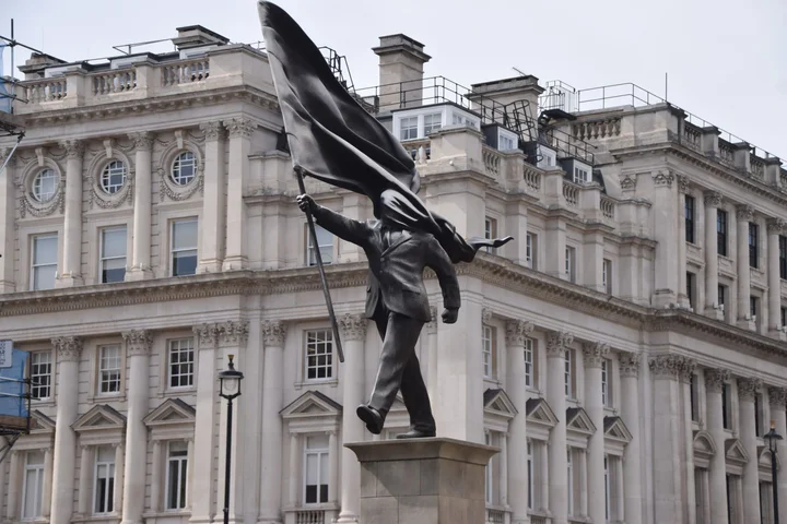 Statue of a man blinded by a flag put up by Banksy in central London