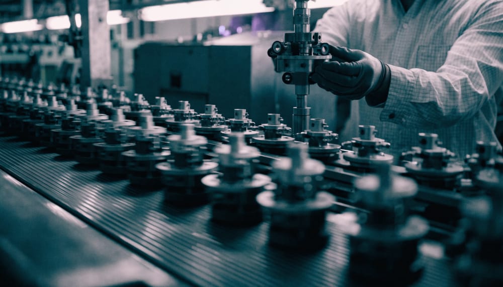 A close up of a factory conveyor belt where identical parts move past, but one station on the line is being swapped out 