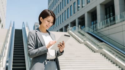 Professional Businesswoman Using Tablet in Corporate Plaza