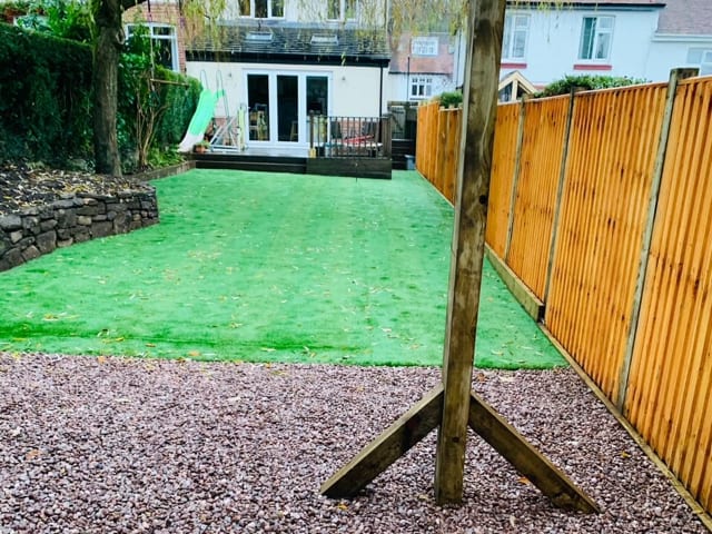 Pristine new articifical lawn with pebbled area