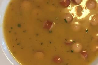 Schüssel mit cremiger sächsischer Kartoffelsuppe, garniert mit Petersilie und knusprigem Speck