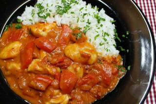 Goldbraun gebratene Hähnchenstücke in cremiger Paprika‑Sahne‑Soße, angerichtet neben fluffigem Reis