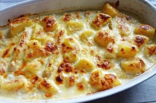 Goldbrauner Spargel-Kartoffel-Auflauf in einer Auflaufform, bedeckt mit geschmolzenem Emmentaler und Parmesan