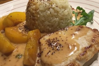 Saftige Minutensteaks auf einem Teller, garniert mit goldbraunen Pfirsichstücken und einer cremigen Pfeffer‑Sauce
