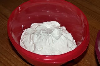 Schüssel mit cremiger, weißer Mayonnaise ohne Ei, verfeinert mit frischen Kräutern und Zitronenscheibe