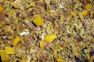 Bunte Pfanne mit gebratenem Hackfleisch, Paprika, zerbröckeltem Feta und Nudeln, garniert mit frischer Petersilie
