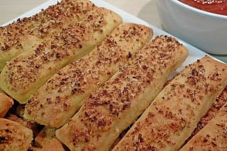 Knusprige Pizzabrötchen mit roter Tomatensauce auf einem Holzbrett