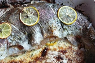 Knusprig gebackene Forelle mit Zitronen‑Mandeln‑Füllung auf einem Backblech