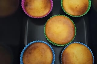 Goldbraune Käsekuchen-Muffins mit glänzenden Mandarinenstücken aus der Heißluftfritteuse, nebeneinander in einem Muffinblech