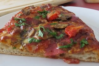 Goldbraune Pinsa mit Salami, Tomaten und geschmolzenem Käse auf Holzbrett