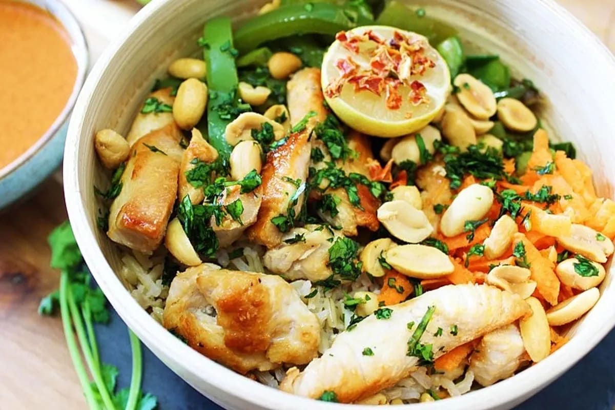 Bunter Indonesischer Reissalat mit Hähnchenstreifen, frischen Paprikastreifen, Frühlingszwiebeln und Erdnuss-Dressing