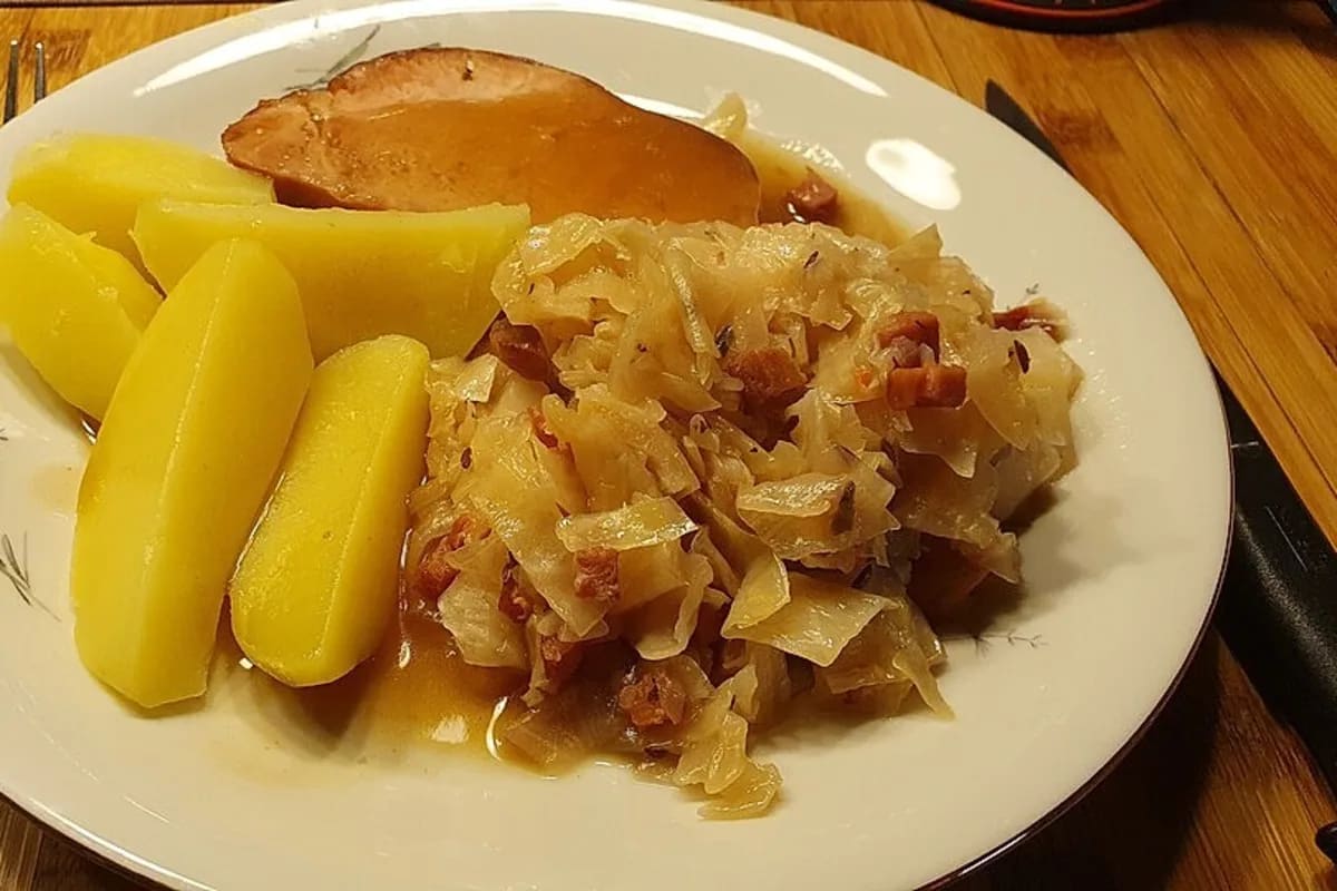 Rustikales Schmorgericht aus Weißkohl, Speck und Gewürzen in einem Schmortopf