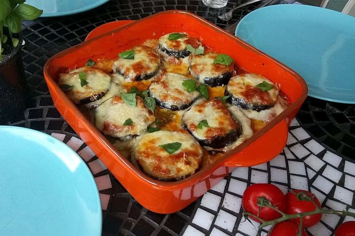 Geschichtete Parmigiana di Melanzane mit goldbrauner Käsekruste im Ofen