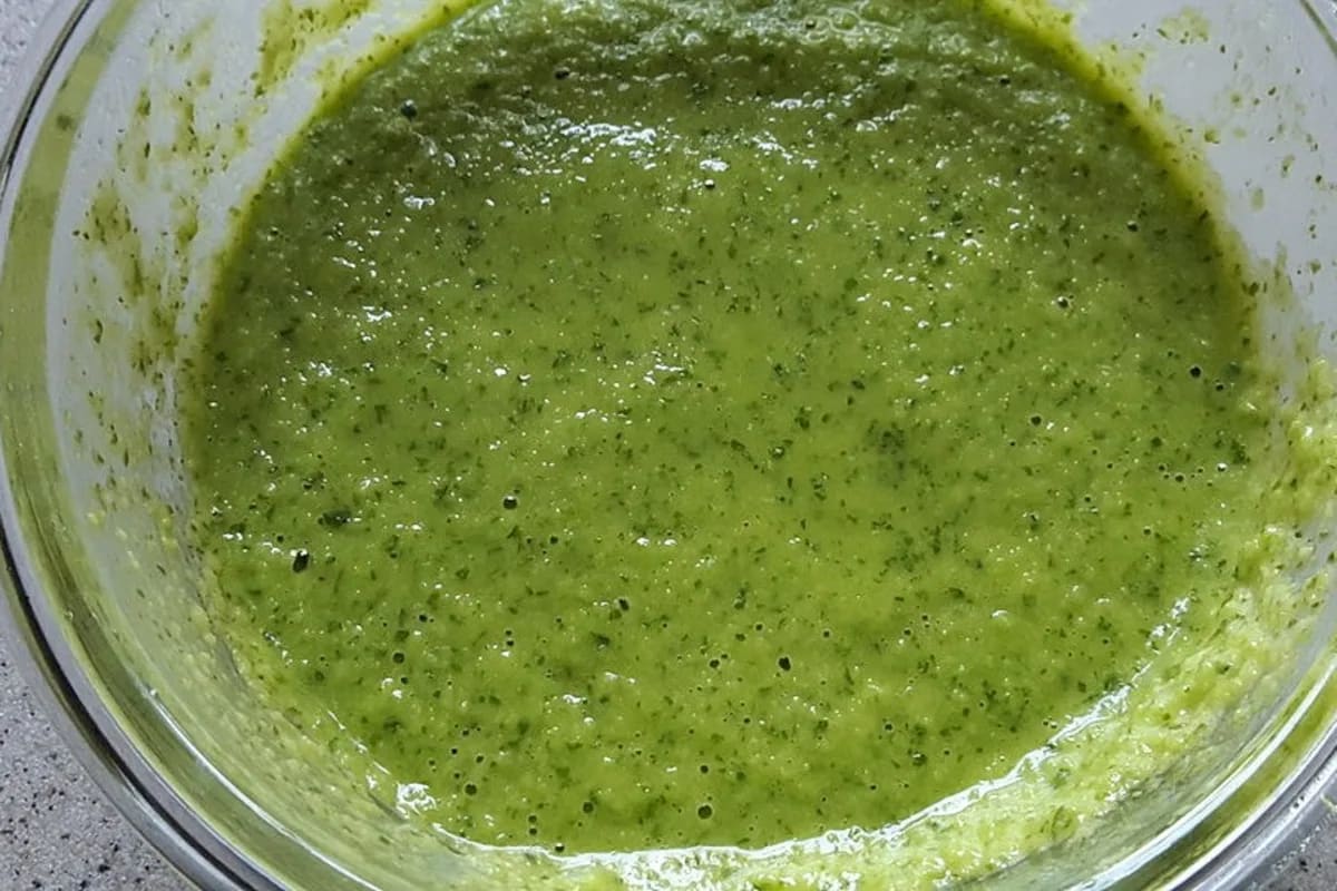 Grüne Mojo Verde Sauce in einer Schale, garniert mit Korianderblättern, neben geräuchertem Ziegenkäse und kleinen Kartoffeln