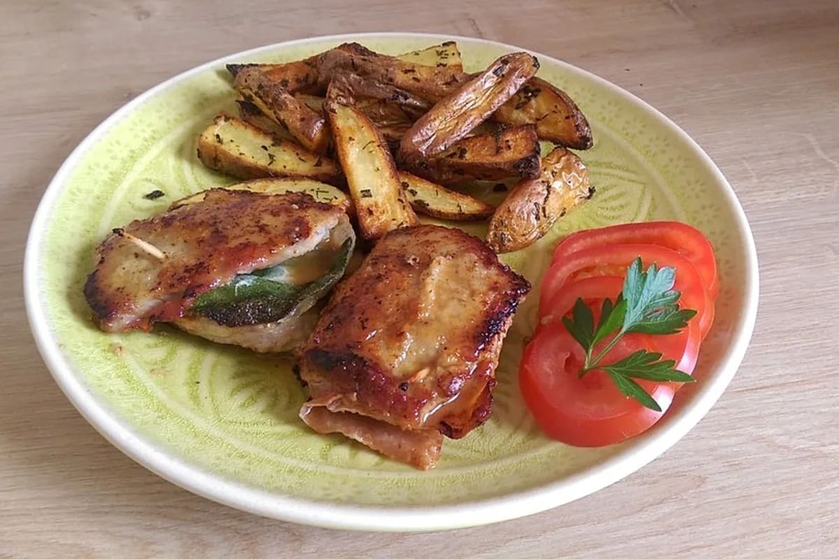 Goldbraun gebratenes Kalbsschnitzel mit knusprigen Rosmarinkartoffeln und grünen Salbeiblättern