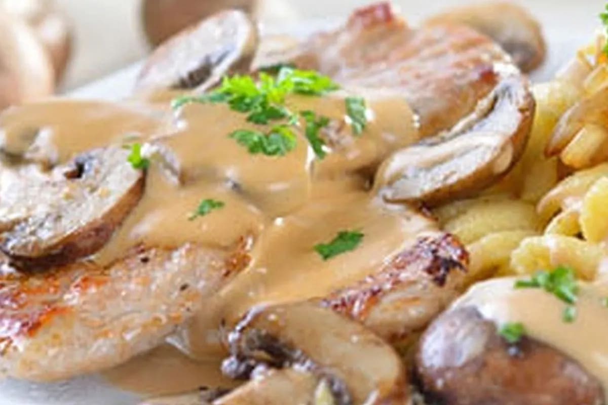 Knusprig gebackenes Sahneschnitzel im Ofen mit goldbraunem Emmentaler und Pilzsauce