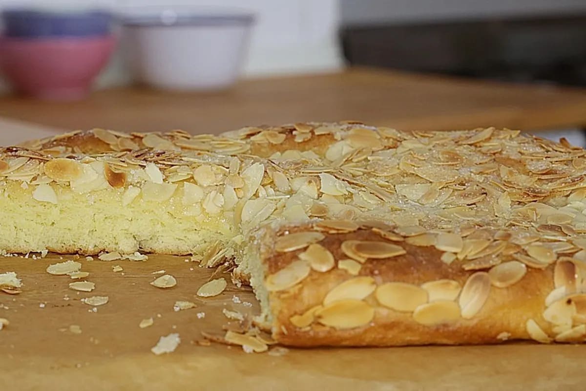Goldbrauner Butterkuchen auf Backblech, bestreut mit Mandeln und Zucker