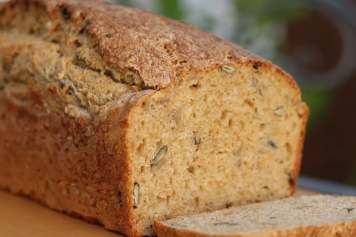Goldbraunes Möhrenbrot in einer Kastenform, mit sichtbaren Möhrenstückchen im Schnitt
