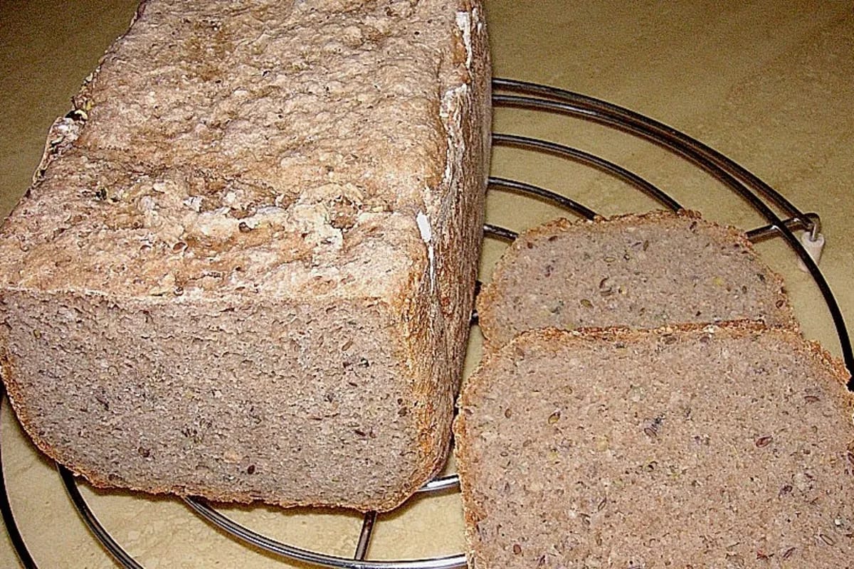 Frisch gebackenes Mischbrot mit goldbrauner Kruste und verstreuten Kernen im Brotkorb