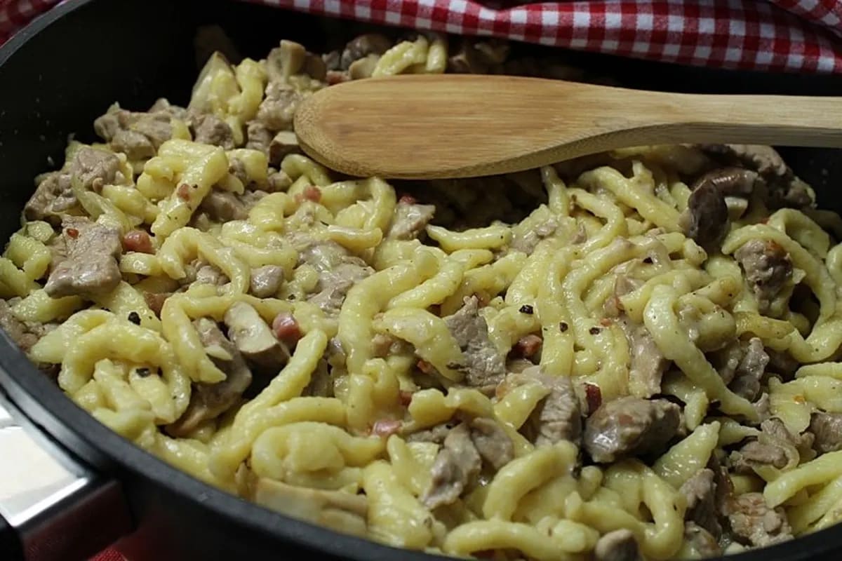 Filetspitzen Angus, Pfifferlinge und knuspriger Speck in einer goldbraunen Spätzlepfanne, bestreut mit Petersilie