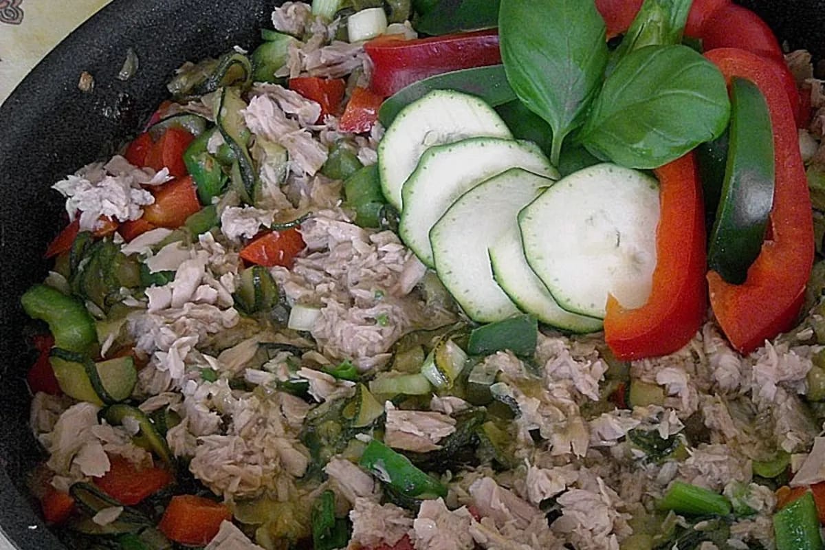 Zucchini‑Paprika‑Pfanne mit goldgelbem Reis, garniert mit frischen Kräutern