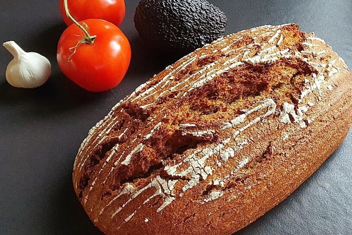 Frisch gebackenes Roggenvollkornbrot mit knuspriger Kruste, in Scheiben geschnitten auf einem Holzbrett