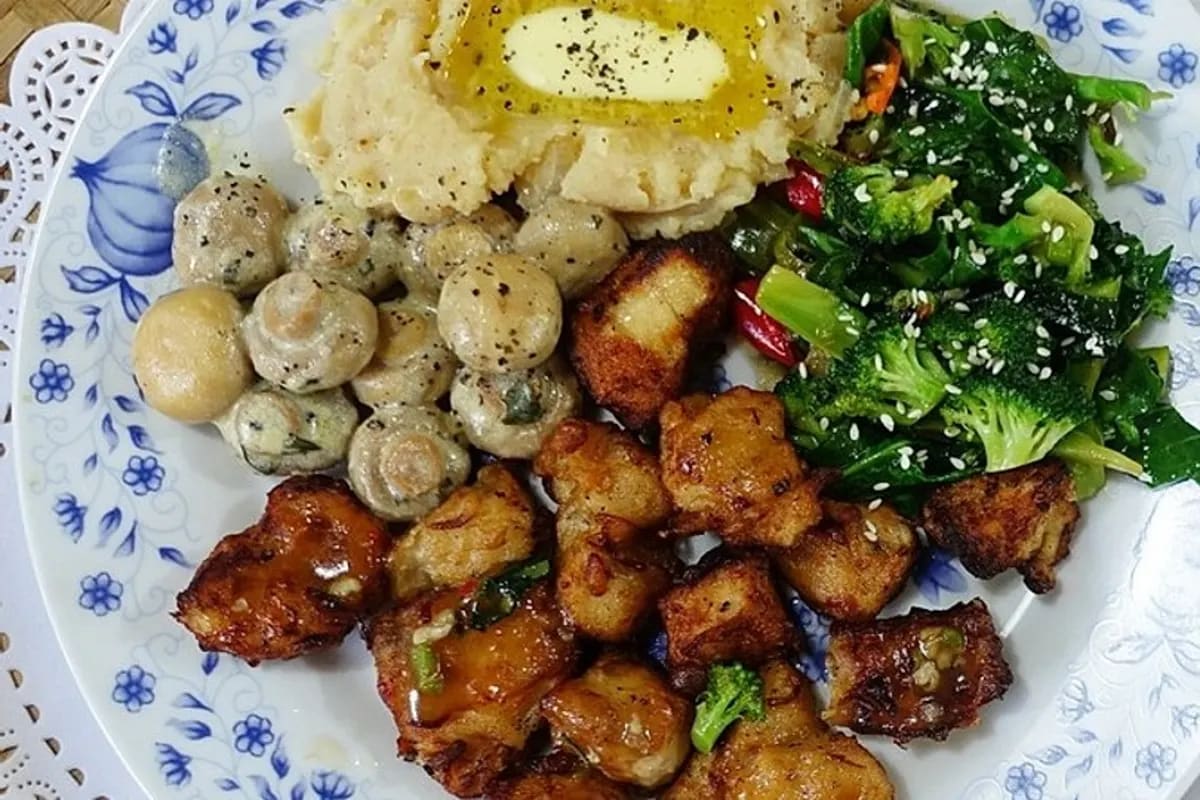 Goldbraun frittierte Thunfischwürfel neben cremigem Kartoffelpüree, Brokkoli und Champignons