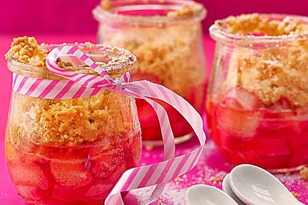 Goldbrauner Rhabarber-Crumble mit knusprigen Streuseln, serviert in einer runden Backform