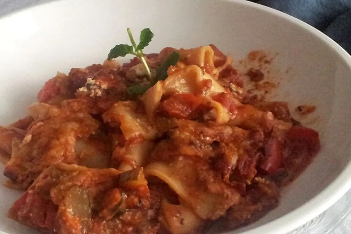 Goldbraun überbackene Lasagne mit roter Paprika, grünem Zucchinigemüse und schmelzendem Käse in einer Auflaufform