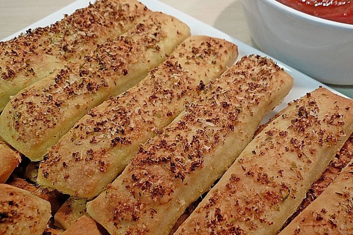 Knusprige Pizzabrötchen mit roter Tomatensauce auf einem Holzbrett