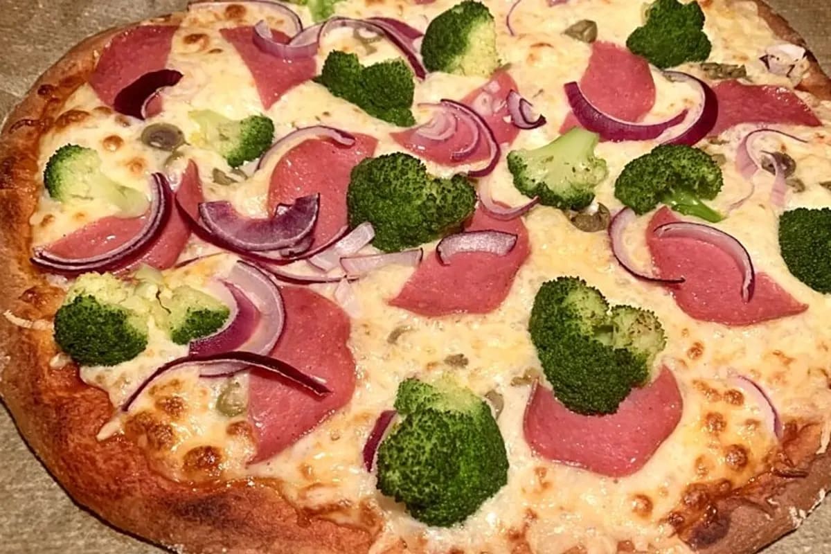 Selbstgemachte Pizza mit Dinkelmehl, knusprigem Rand und frischer Tomatensauce