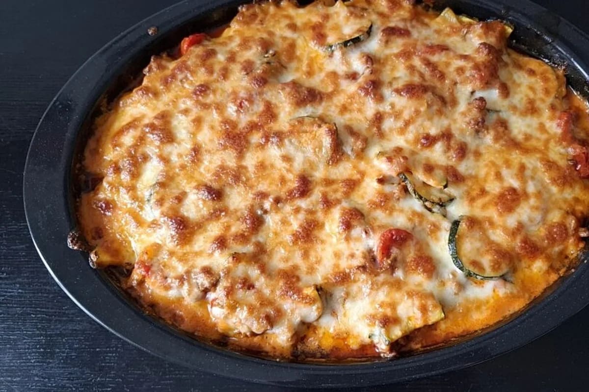 Goldbraun überbackener Gnocchiauflauf mit geschmolzenem Mozzarella, Zucchinischeiben und frischen Kräutern