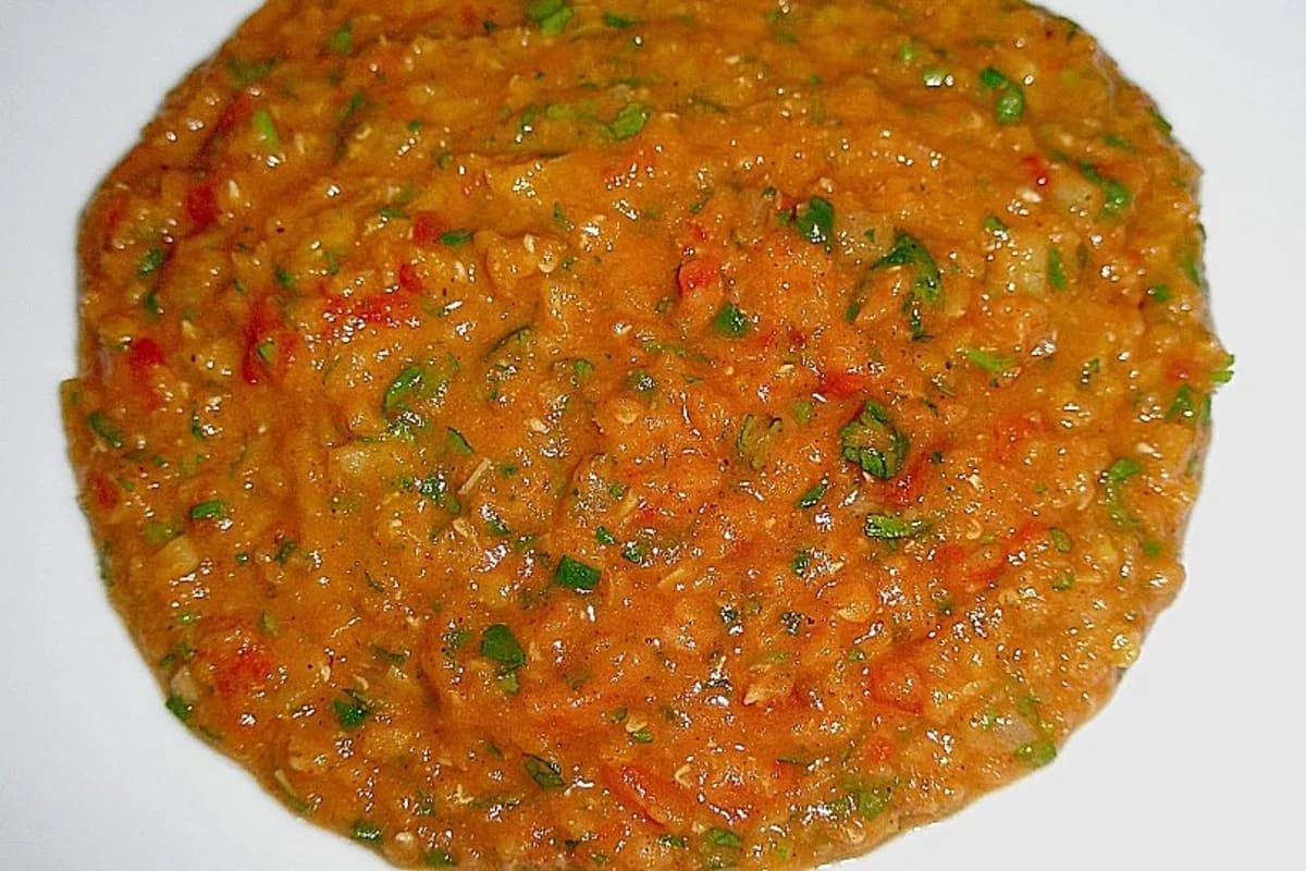 Rotes Linsen‑Curry in einer Schüssel, garniert mit frischem Koriander und serviert neben Basmatireis