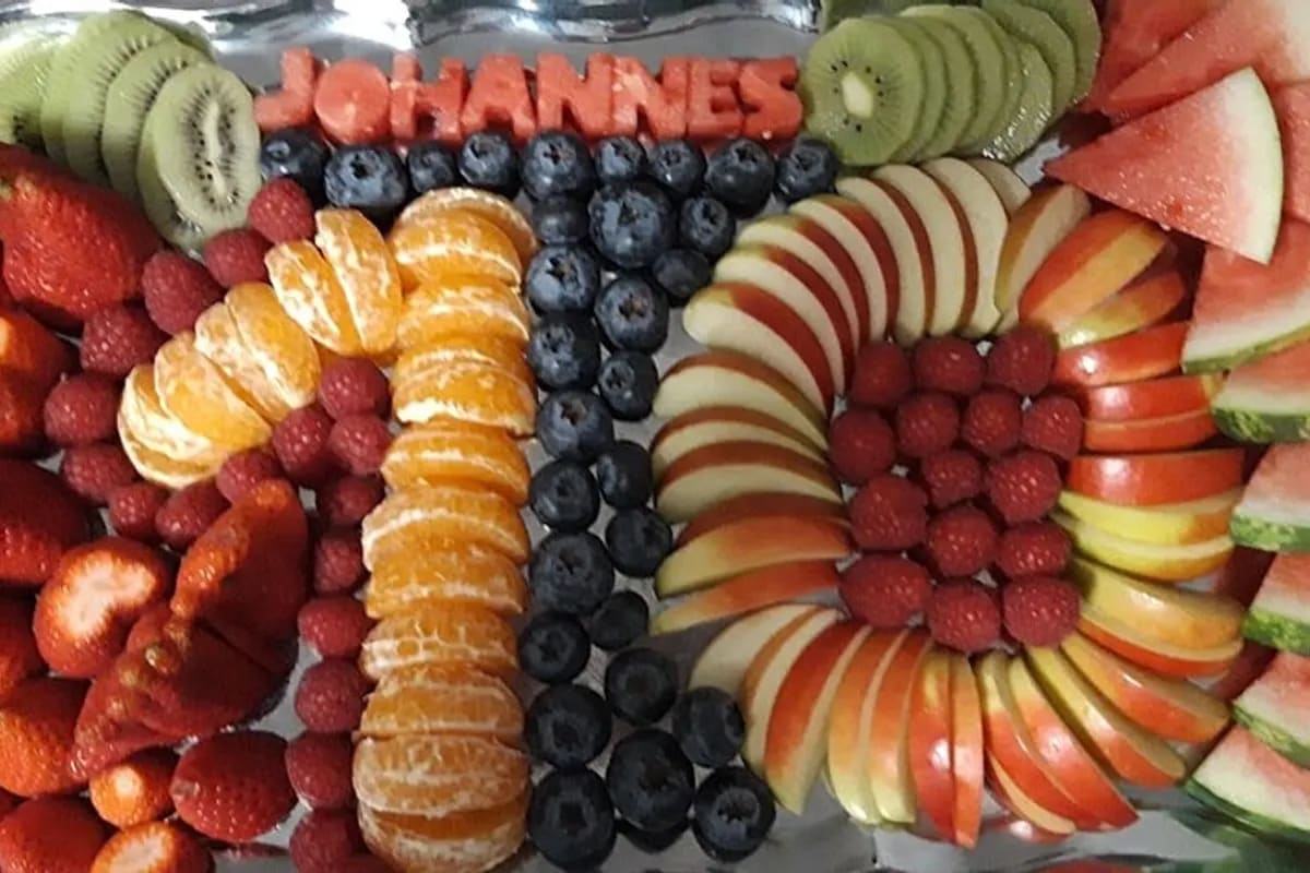 Bunte Obstplatte in Form einer 0 und 1, kunstvoll arrangiert auf einer rechteckigen Servierplatte