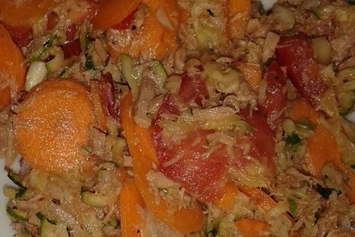 Bunter kanarischer Kartoffelsalat mit Thunfisch, frischen Radieschen, Karotten, Zucchini, Tomaten und Petersilie, angerichtet auf rustikaler Holzplatte