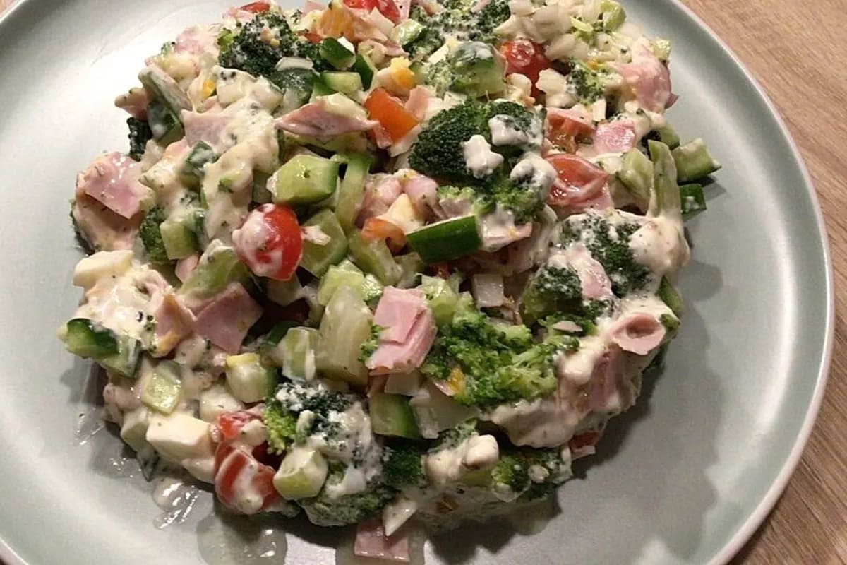 Bunter Brokkoli Salat mit cremigem Crème Fraîche-Dressing, garniert mit Tomaten, Gurke und Lauchzwiebeln