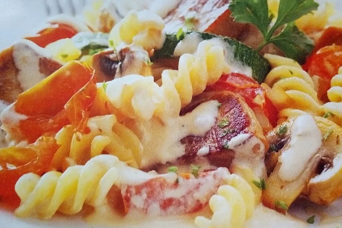 Schweinefiletstreifen in cremiger Tomaten‑Pilz‑Sauce auf al dente Penne, garniert mit Petersilie