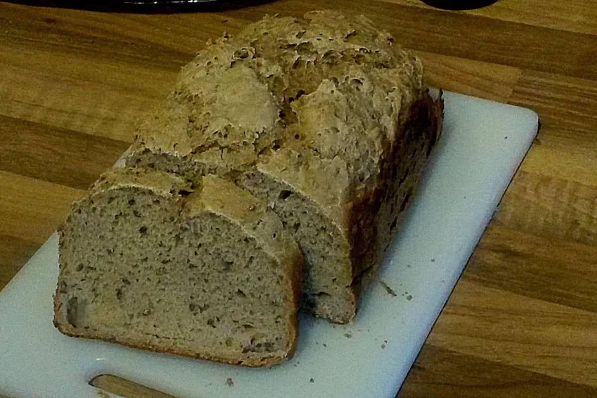 Goldbraunes Roggenbrot mit knuspriger Kruste, aufgeschnitten und auf einem Holzbrett liegend