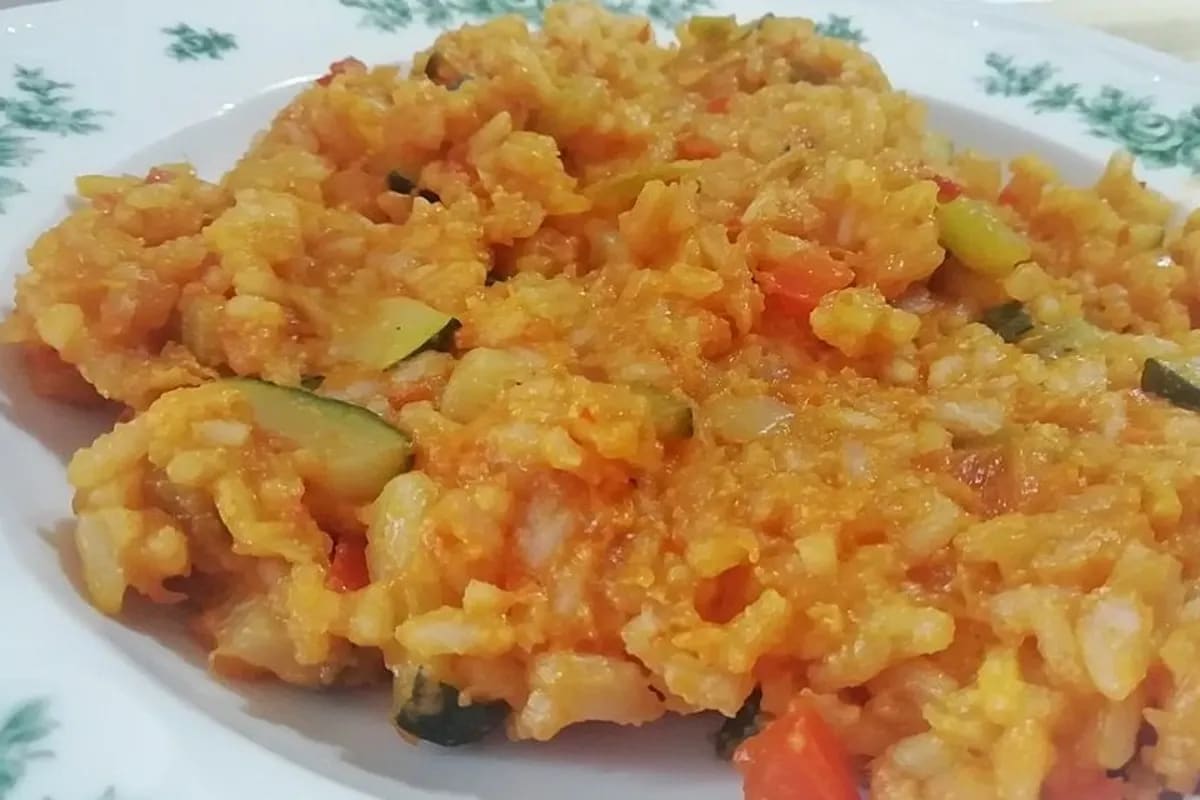 Bunter Paprika‑Zucchini‑Reis mit geröstetem Sesam, serviert in einer weißen Schüssel
