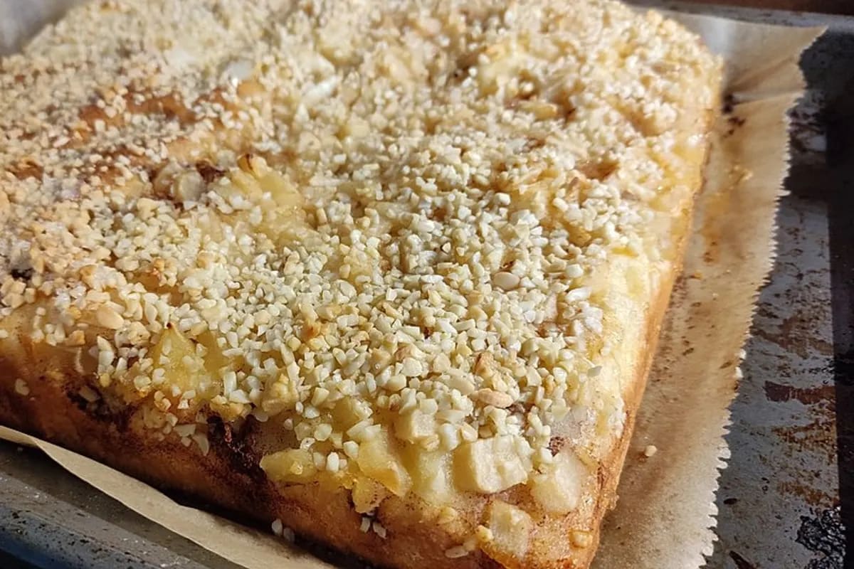 Goldbrauner Apfel‑Butterkuchen mit Zimtbutter-Füllungen und Mandelblättchen, aus dem Ofen genommen