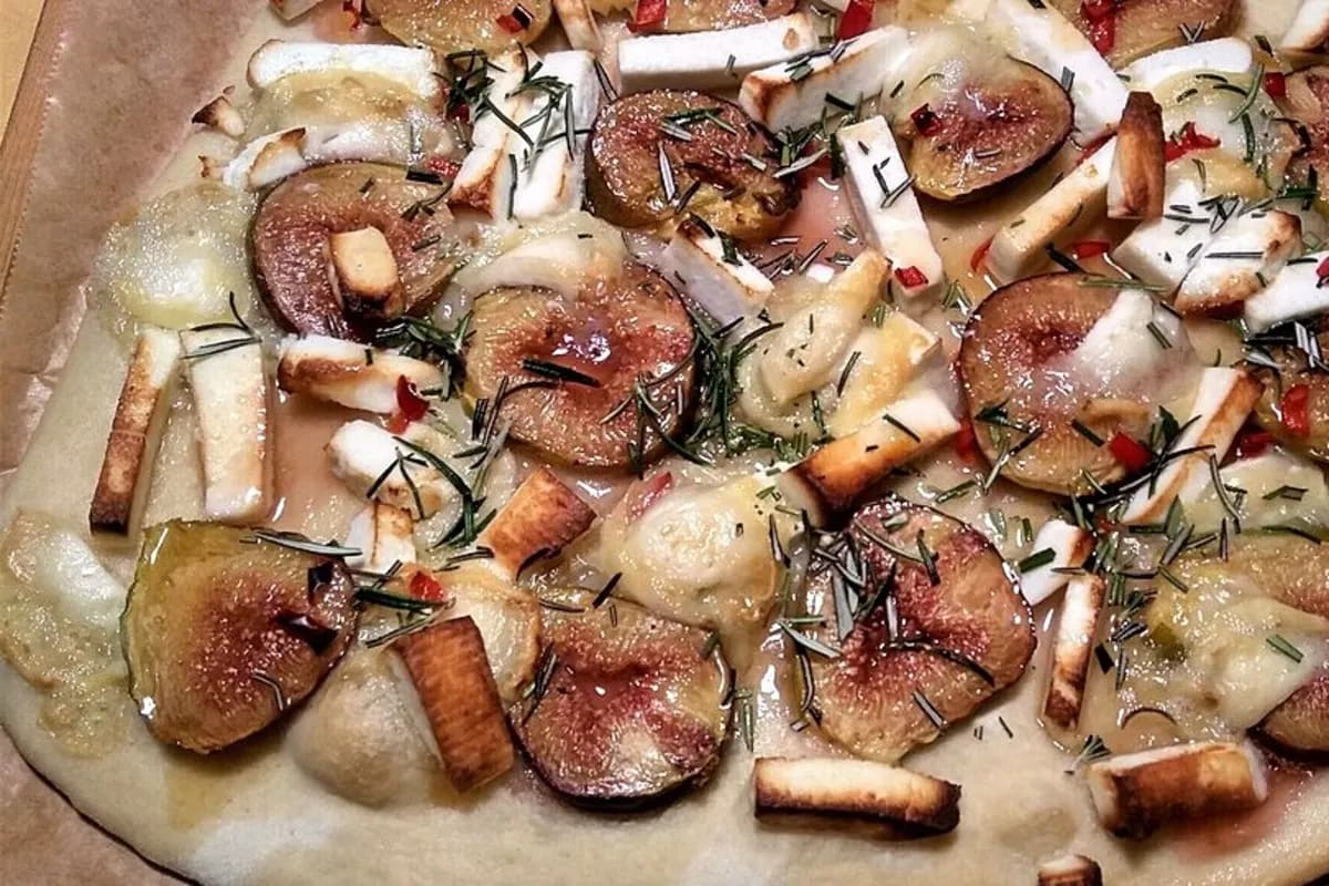 Frisch belegte Pizza mit Ziegenkäse, Feigen, Honig und Rosmarin, knusprig aus dem Ofen