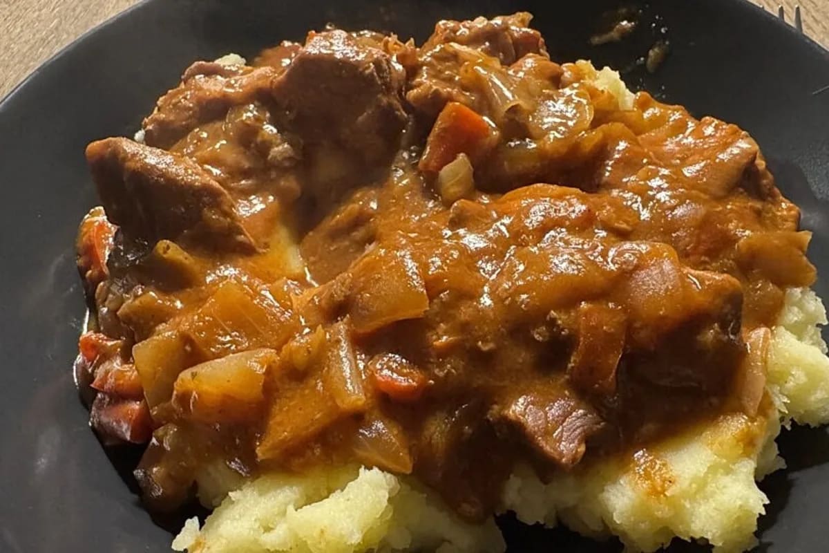 Goldbraun gebackenes Zwiebelschnitzel mit karamellisierten Zwiebelringen auf einem Backblech