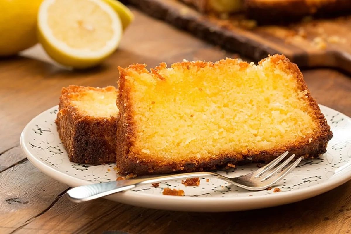 Goldbrauner Zitronenkuchen in Kastenform, mit Zitronenscheiben garniert